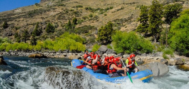 Grupo haciendo rafting en los rápidos de un río
