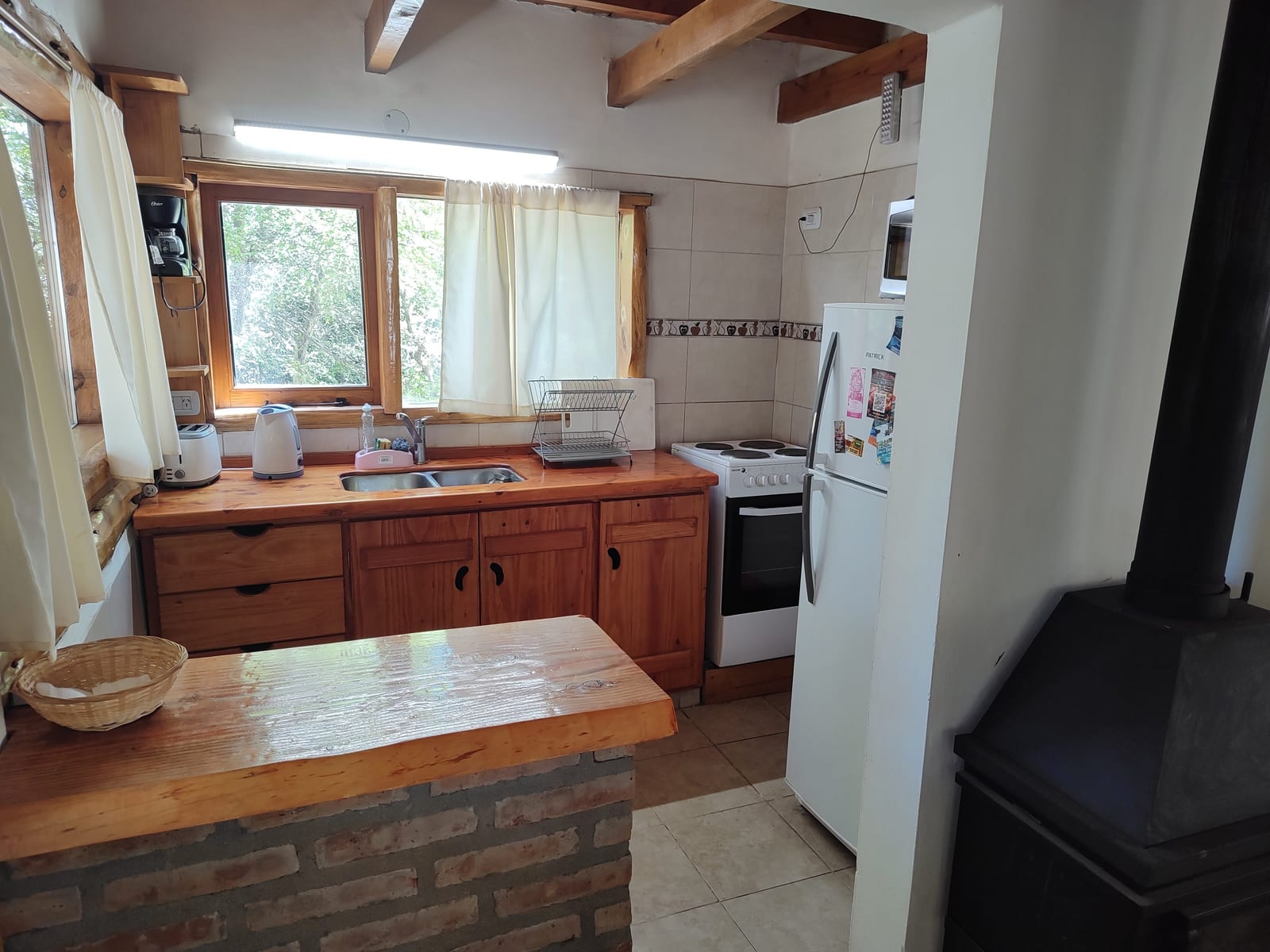 Cocina con barra de ladrillos y heladera.