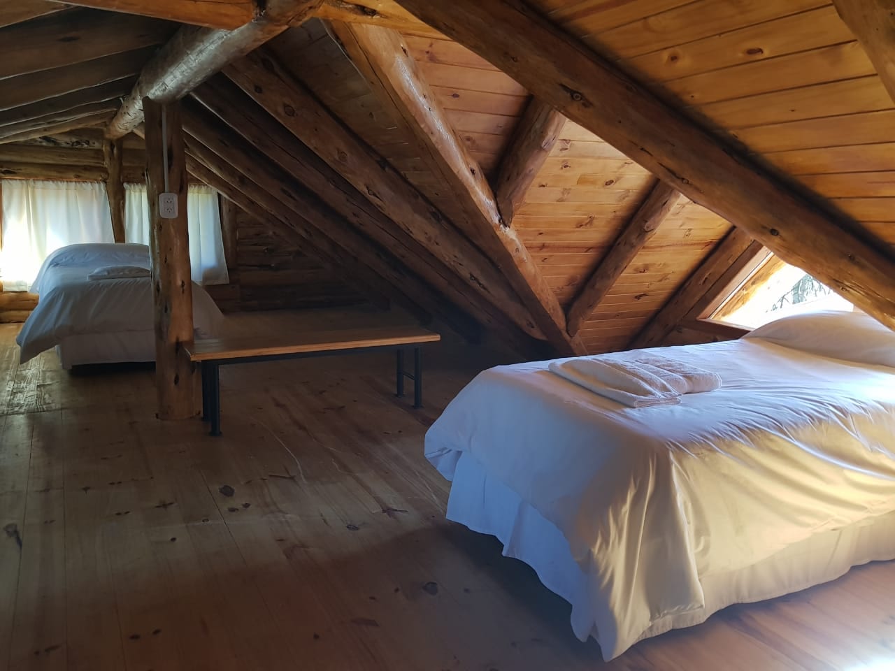 Altillo con camas bajo un techo de madera.